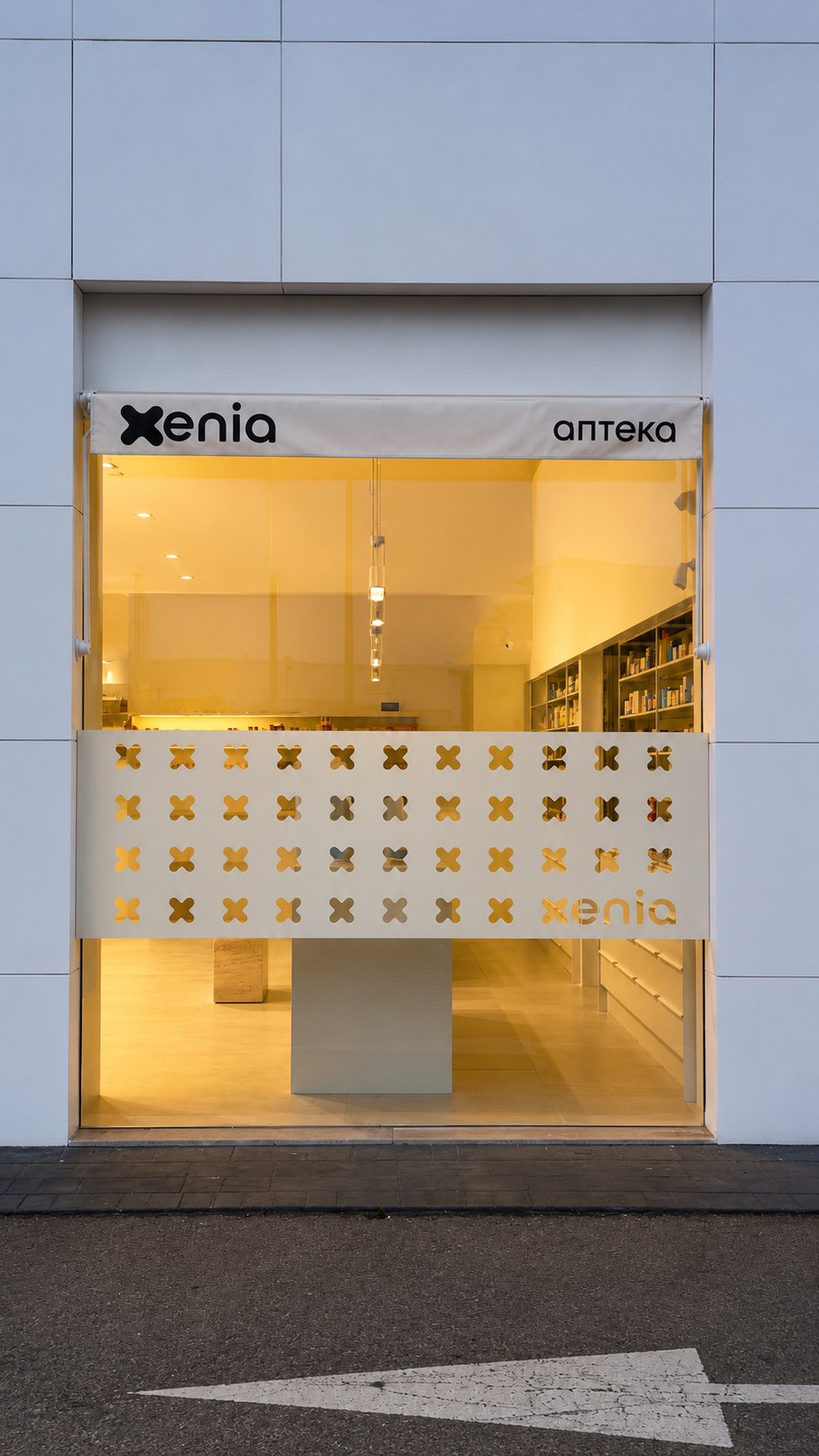 Fachada de Farmacia Xenia con identidad gráfica en el cerramiento